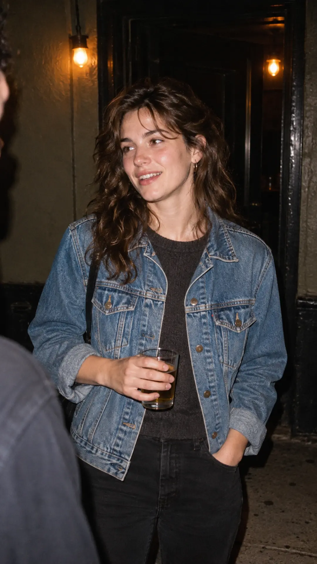 Direct-flash nighttime portrait with a denim jacket and warm background lights