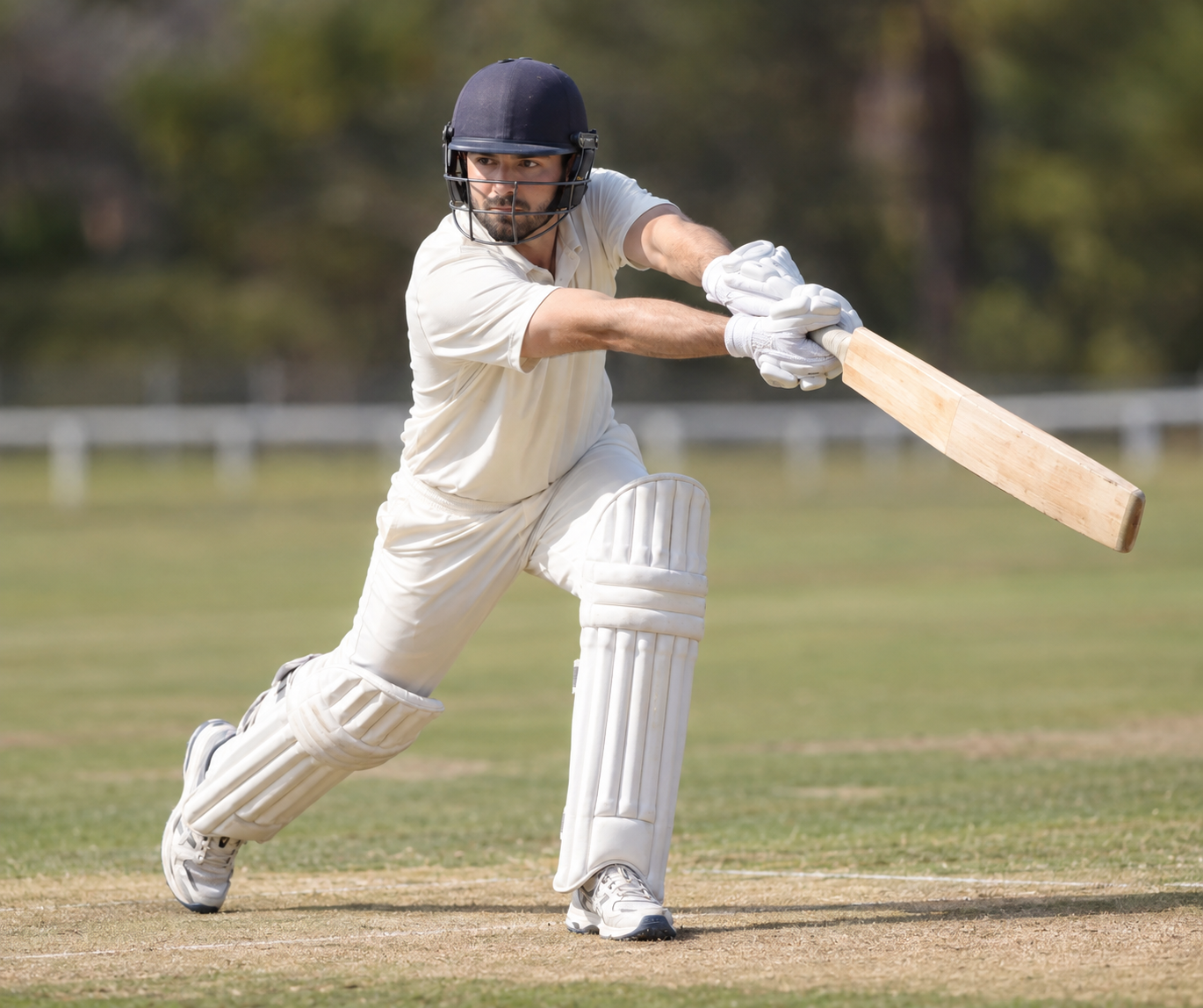 Cricket player finishing a front-foot cover drive with a single bat.