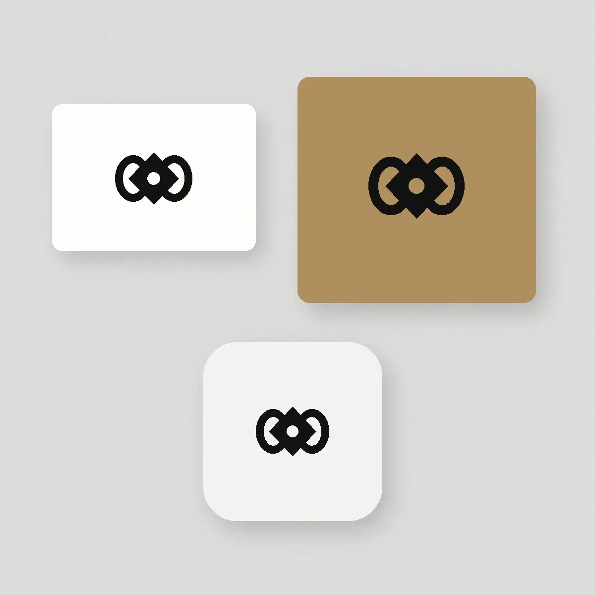 A flat lay of a blank business card, kraft box lid, and app icon tile each carrying the same black logo symbol.